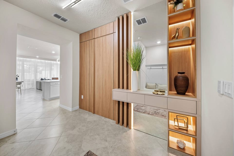 Welcome to a beautifully designed entryway featuring warm wood accents and sleek cabinetry that exude contemporary charm. Soft lighting highlights the inviting textures, creating a cozy atmosphere for your vacation home adventure.