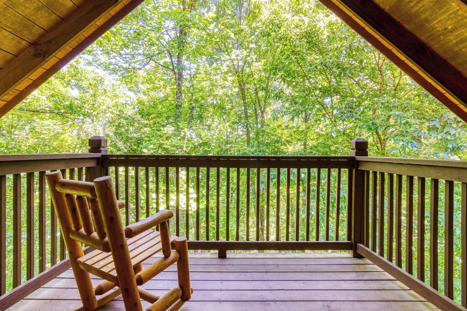 Private covered balcony with rocking chair and serene wooded views