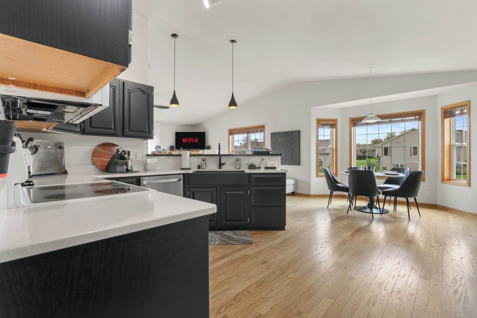 Fully stocked kitchen with 4 barstools at the breakfast bar, complimentary coffee station, 5 seat dining table, and visibility to the living room.