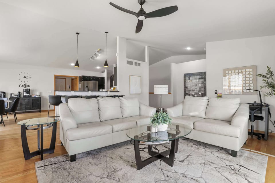 Main level living room with gas fire place, 55" smart TV, sofa seating, and a walk out sliding door to the deck.
