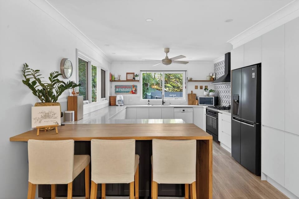 Pull up a stool at the breakfast bar, where morning coffee and easy meals unfold in a bright, relaxed setting.