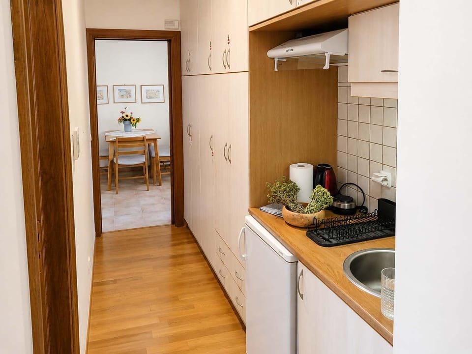 Fully Equipped Kitchenette with Storage and Dining Area View