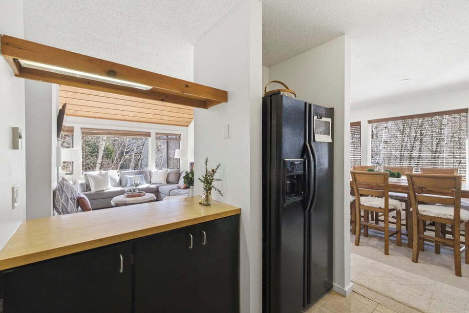 The kitchen from the dining side, showing the fridge and counter space — the dining area is just steps away, keeping the flow easy for bigger groups.