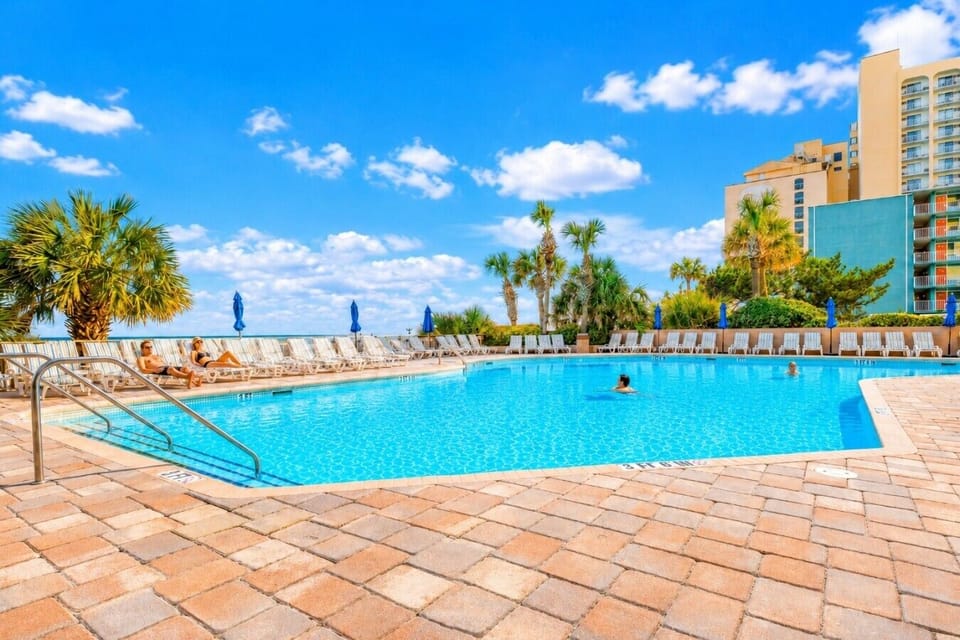 Wake up to sweeping Atlantic views at this bright oceanfront retreat at Coral Beach Resort, with a fireplace and dining nook nearby.