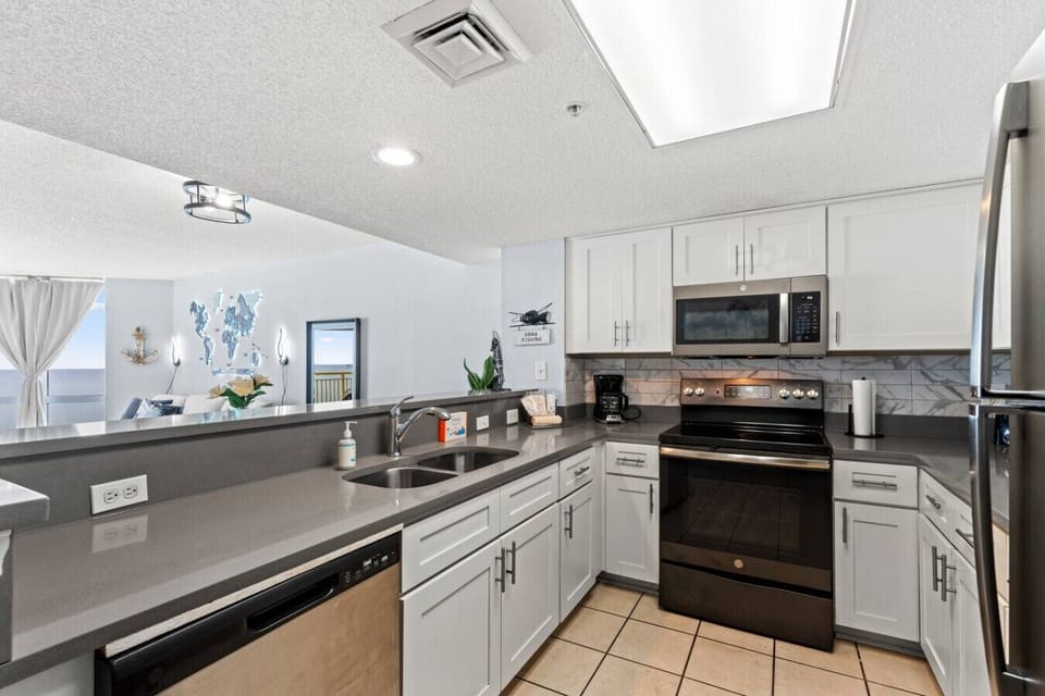 Kitchen with marble countertops stainless steel appliances and oceanfront views