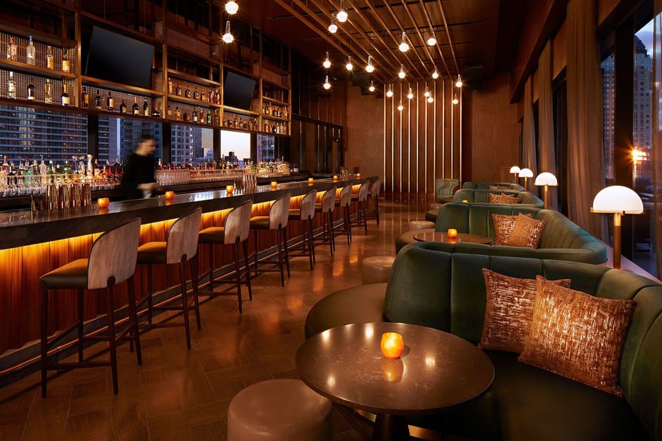 Sip craft cocktails at the glowing bar with city views.
