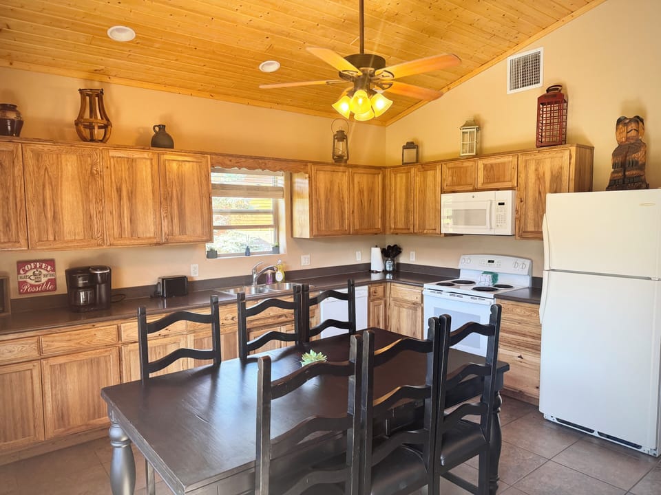 Rustic full kitchen with vaulted wood ceiling and dining for six