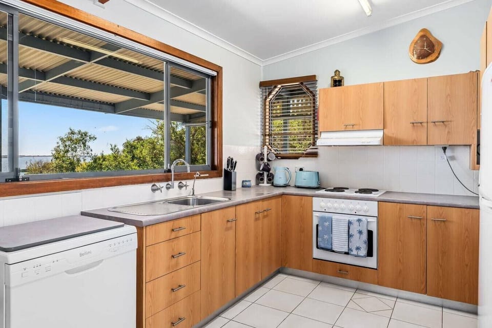 Filled with natural light, the kitchen offers everything needed for easy meal preparation, with generous bench space and garden views.