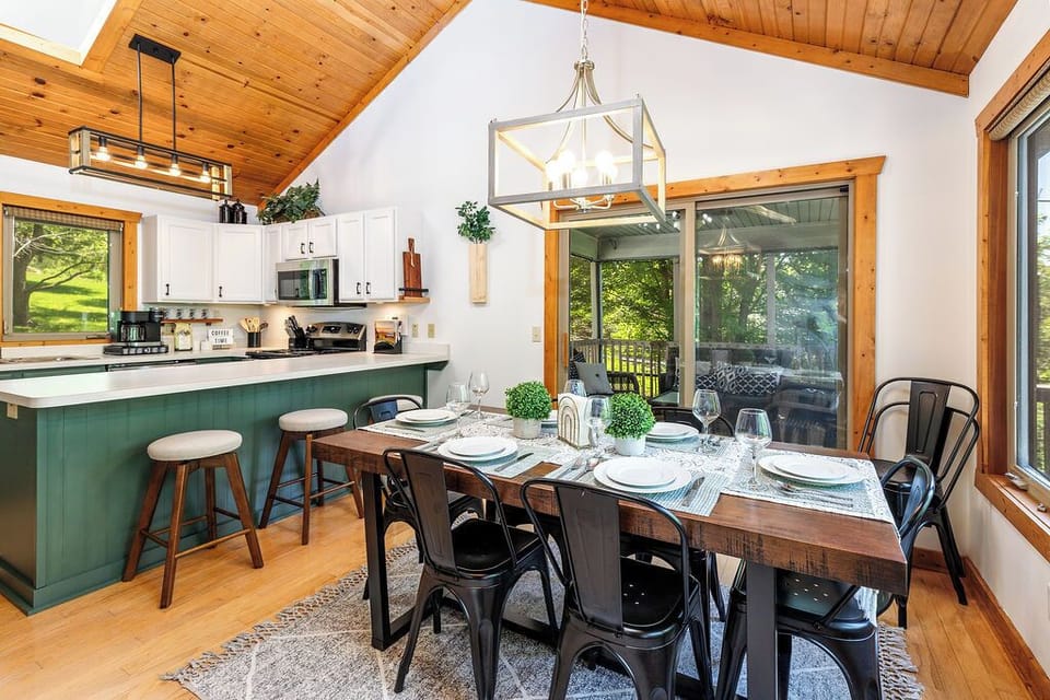 Dining area that looks over the wooded backyard -- table accommodates 6 with 3 additional seats at the breakfast bar