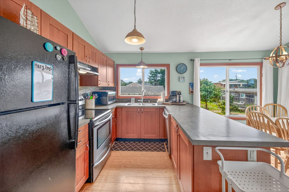 Your fully equipped kitchen with warm wood cabinets and granite counters awaits your culinary adventures, complete with garden views.
