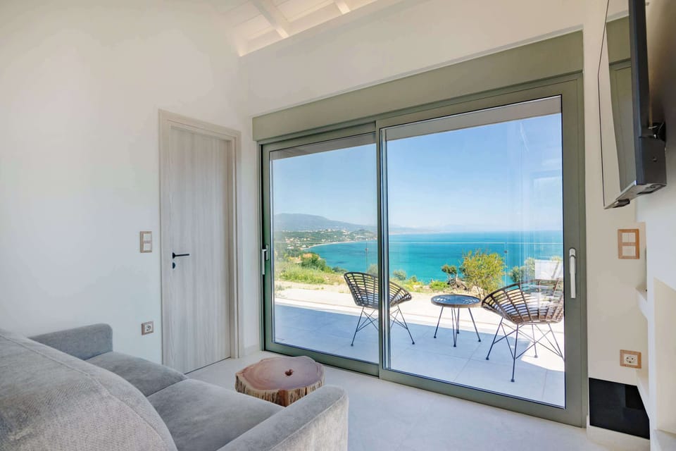 Living room with Floor-to-Ceiling Window and Sea View
Bright and elegant common area featuring a comfortable sofa  and a large window framing beautiful sea views, filling the space with natural light and serenity.