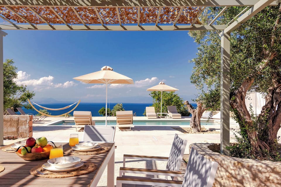 Outdoor Dining Area with Sea Views and Shaded Pergola
