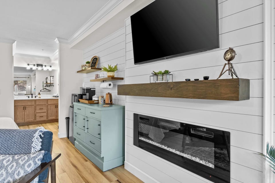 Electric fireplace with a mounted smart TV above. Stream your shows with the fire glowing in the background.