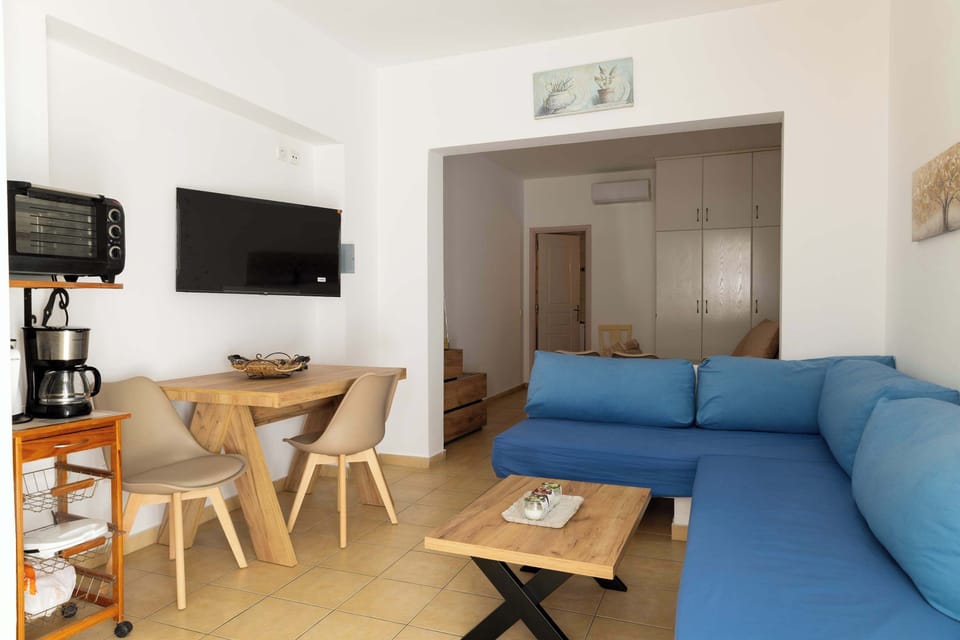 Open-plan living room with sofa, TV, and dining table