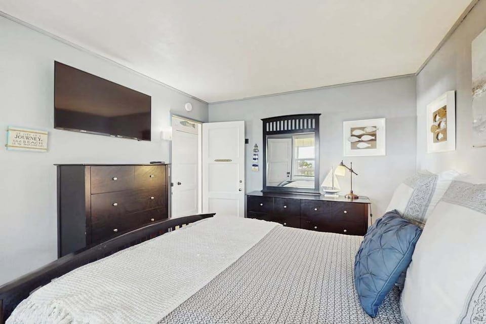 Your oversized wall-mounted TV and streamlined dark-wood storage make this bedroom a self-contained retreat — close the door and let the Sonoma Coast quiet lull you to sleep.