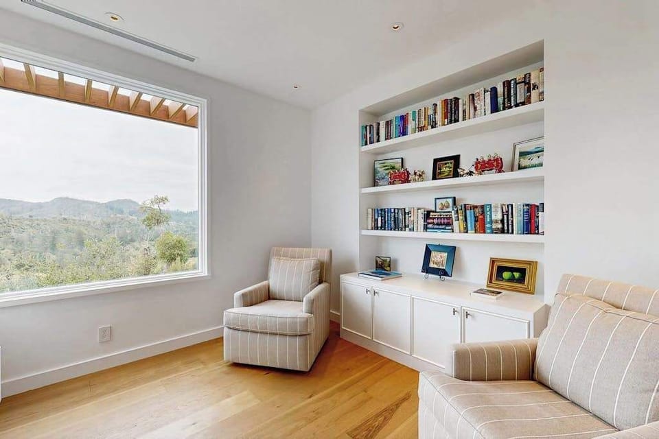 Steal away to your private reading nook with built-in bookshelves and mountain views — a quiet corner perfect for planning tomorrow's Calistoga winery route.