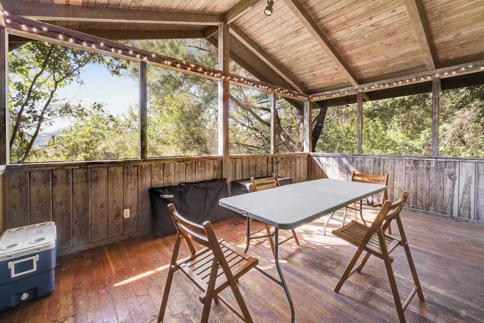 String lights twinkle overhead as your screened porch transforms into an enchanting evening gathering spot surrounded by Cloverdale's canopy of trees.