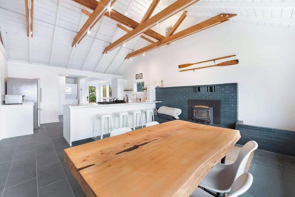 Gather around the live-edge wood dining table beside a striking blue-tiled hearth — your wine country dinner party starts here.