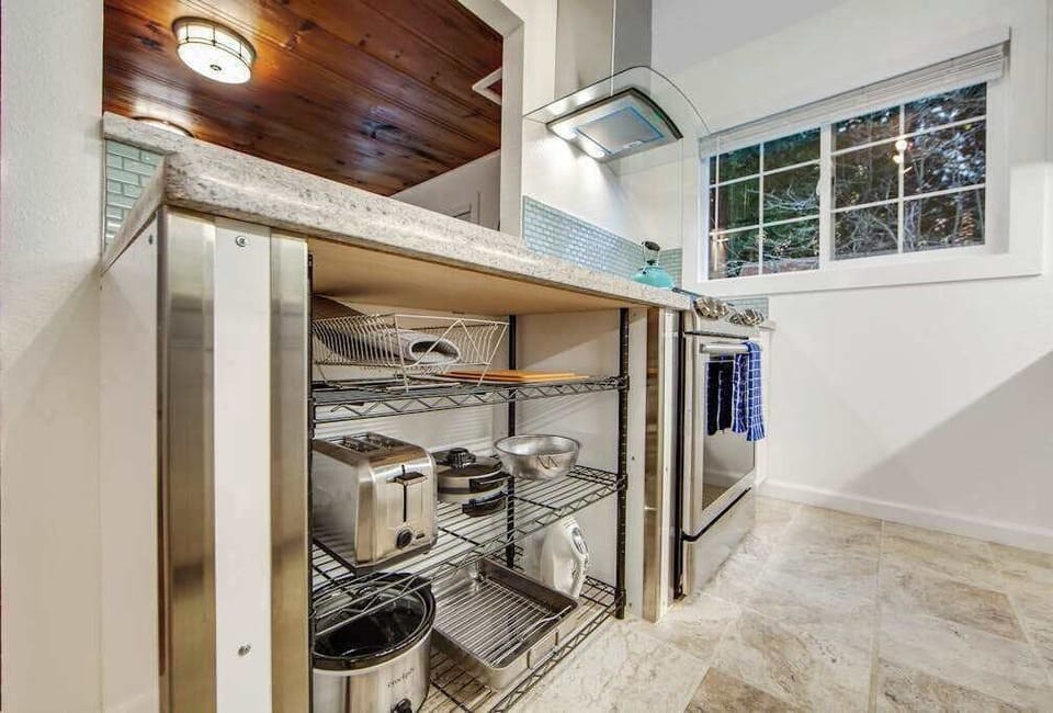 Everything you need to cook a harvest-inspired meal awaits — well-stocked shelving keeps pots, pans, and small appliances within easy reach.