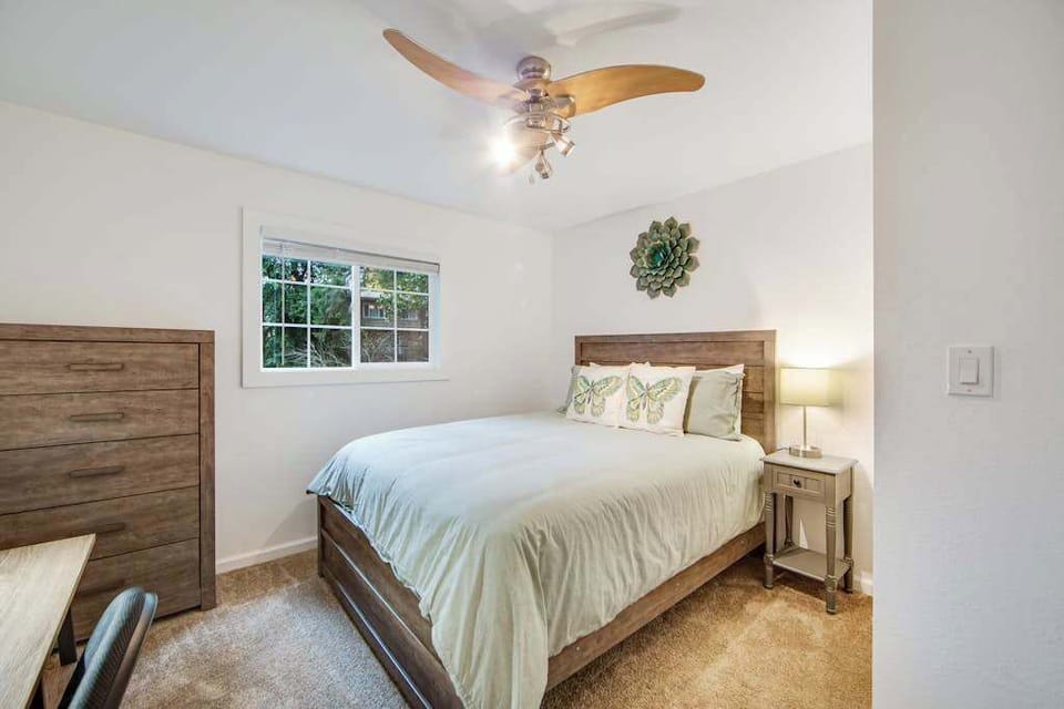Treetop greenery peeks through the windows of this tranquil bedroom, where cool forest air and ceiling fan breezes lull you to sleep.