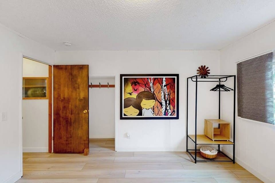 Bold original art and an open-concept wardrobe add personality to your bedroom — a nod to the creative, eclectic spirit of the Russian River community.
