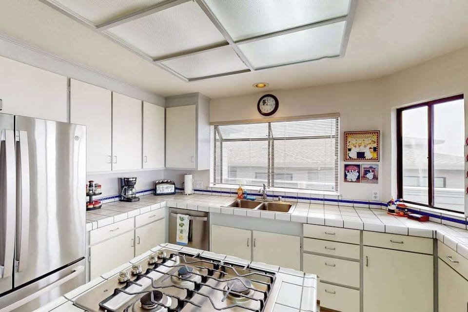 Prep your fresh catch from Bodega Bay at the tiled counters while natural light pours through kitchen windows overlooking the Sonoma Coast