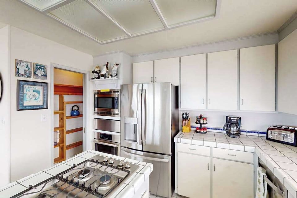 Brew your morning cup before exploring Doran Beach — your well-stocked kitchen features a coffee maker, microwave, gas range, and walk-in pantry