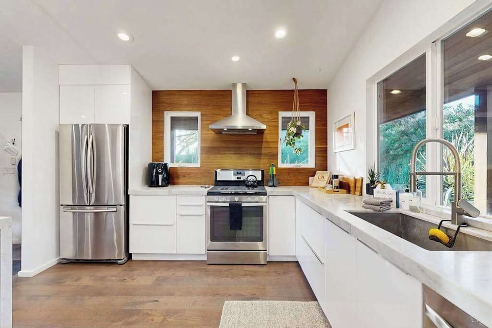 Stainless steel appliances and a gas range with hood vent make cooking with Sonoma County farmers market ingredients a pleasure.