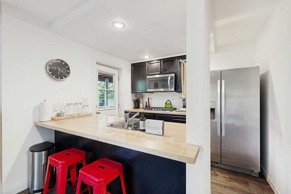 Guest suite kitchenette with breakfast bar and cheerful red stools — grab a quick bite before heading to Healdsburg Plaza.