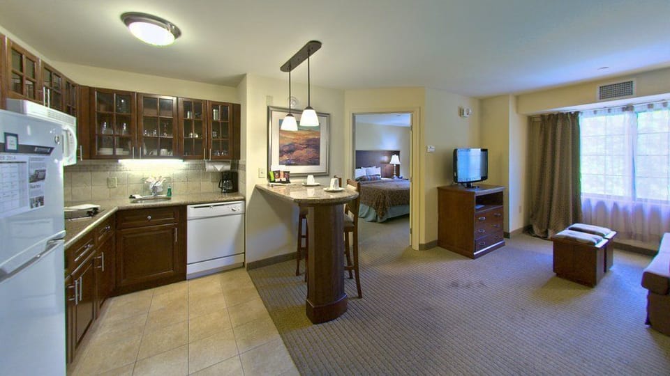 Cook up a delicious meal in your fully equipped kitchenette, with stylish dark cabinetry and bar seating for a cozy dining experience.