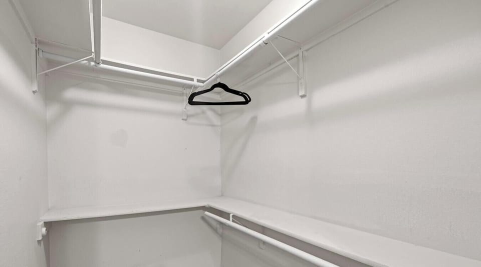 A walk-in closet with shelving and rods lets you unpack fully — no living out of a suitcase.