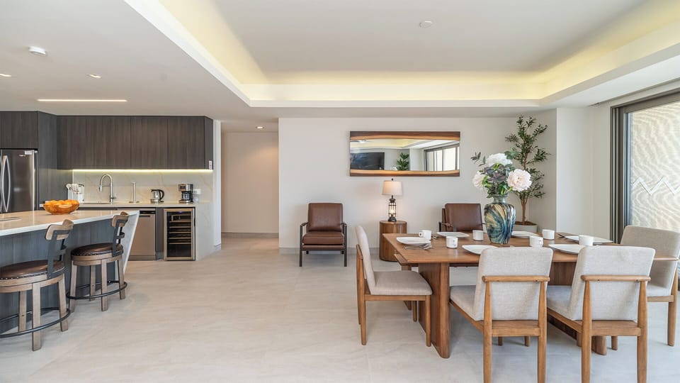 The dining table seats six, with more seats at the kitchen counter