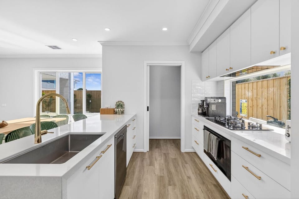 Sleek, fully equipped kitchen with island bench, quality appliances, and plenty of space to cook and gather.