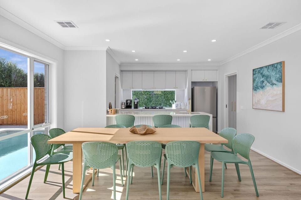 Stylish dining area overlooking the kitchen and pool—ideal for shared meals and entertaining.