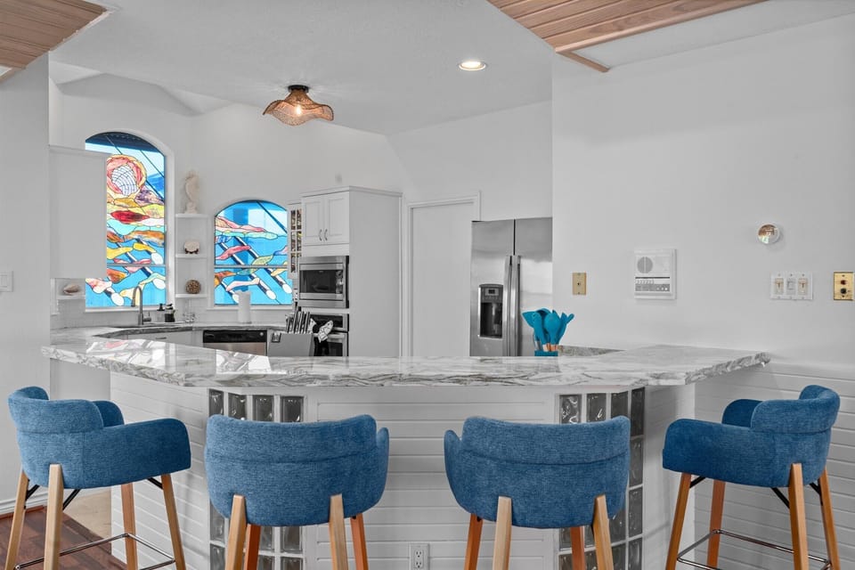 Kitchen island with bar seating, pendant lighting, and open layout connecting to living space, ideal for social cooking and entertaining.