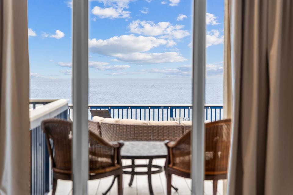 Bright living area with large windows and direct bay views, showcasing natural light and coastal scenery.