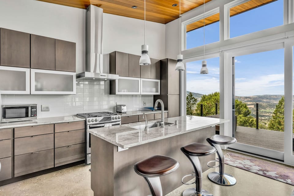 Modern gourmet kitchen with high-end stainless steel appliances and an island breakfast bar.