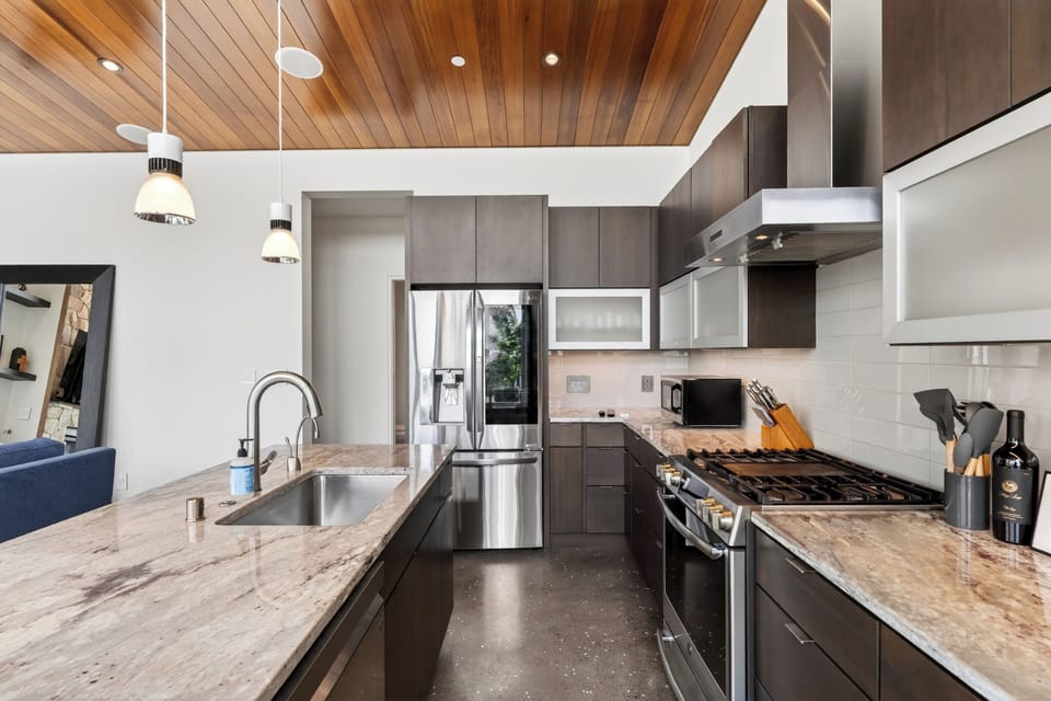 Sleek kitchen featuring granite countertops and a professional-grade range.
