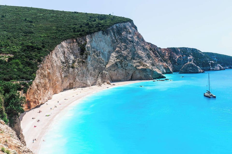 At Porto Katsiki, about 7 km away, steep white cliffs drop into bright turquoise water. The descent leads to one of Lefkada’s most striking beaches, where the landscape feels dramatic and open.