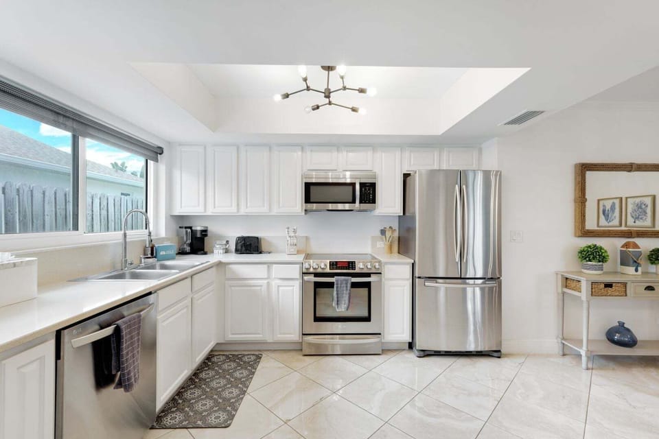 Bright, coastal-style kitchen with stainless steel appliances and a clean, airy feel—perfect for easy, relaxed meals.
