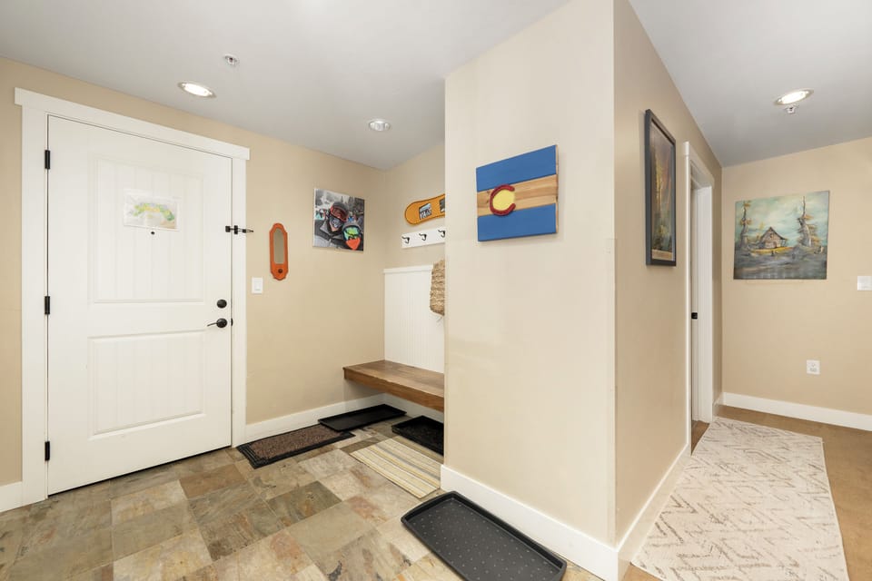 Step into your welcoming entryway at Base Camp 305 with built-in bench, perfect for settling in after mountain adventures. The Colorado flag artwork sets the tone for your stay.