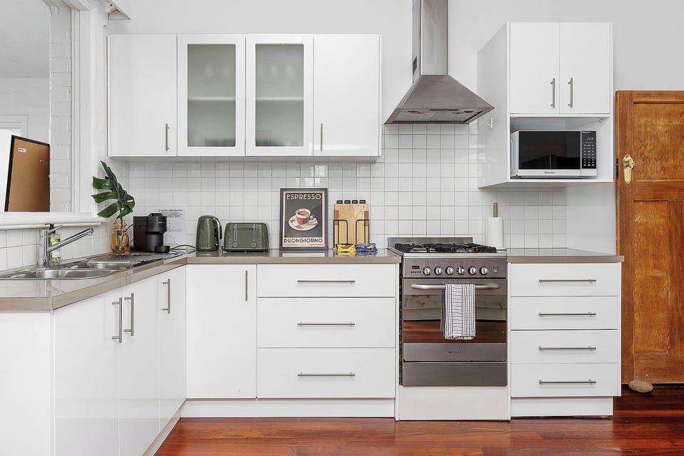  Enjoy the sleek, modern design, full cooking facilities, and warm wooden floors in this inviting kitchen space.