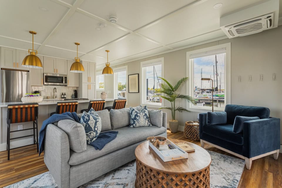 The open living and dining space flows seamlessly into a fully equipped kitchen, with marina views through every window and seating for the whole crew.