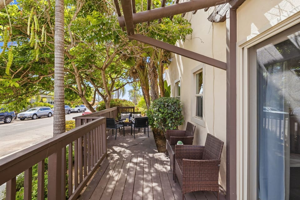 Elevated wooden deck, offering a completely detached and private outdoor living space with no shared areas. The layout flows seamlessly from the home, providing a generous area for both dining and lounging amidst the lush coastal greenery.