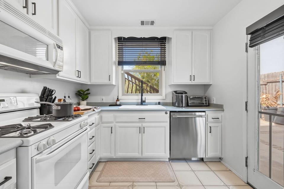 This fully equipped kitchen features a full-sized refrigerator, oven, and microwave, perfect for preparing meals at home.