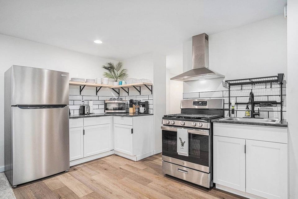 Full kitchen equipped with stovetop pots and pans, measuring cups, silverware, essential cooking utensils, cutting board, plates, bowls, cups, mixing bowls, k-cup coffee maker, and microwave... Everything you need for preparing a meal! - 616.287.2210