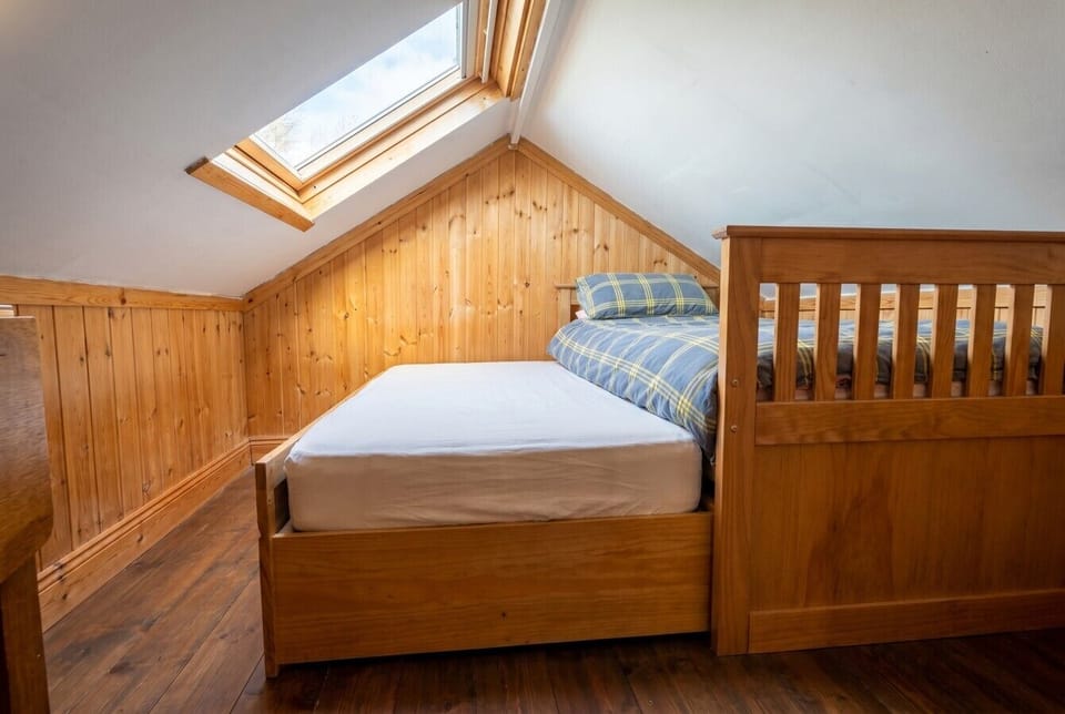 Bright attic twin room with pine-clad walls and a skylight for stargazing.