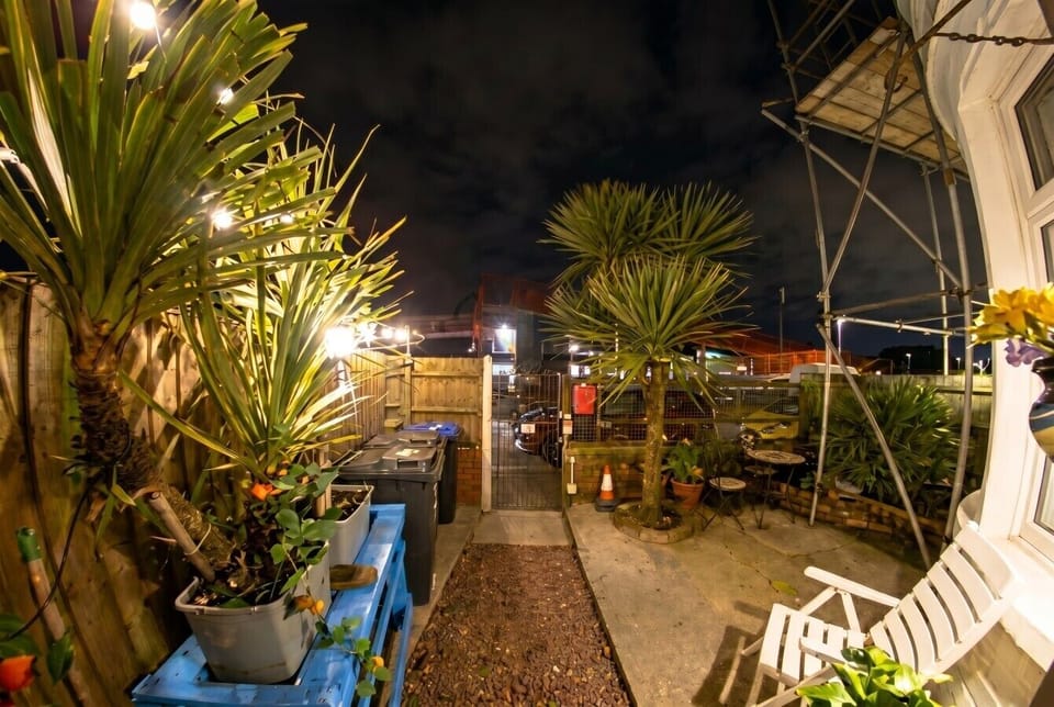 Fairy-lit courtyard with palm trees and seating for evening fresh air.