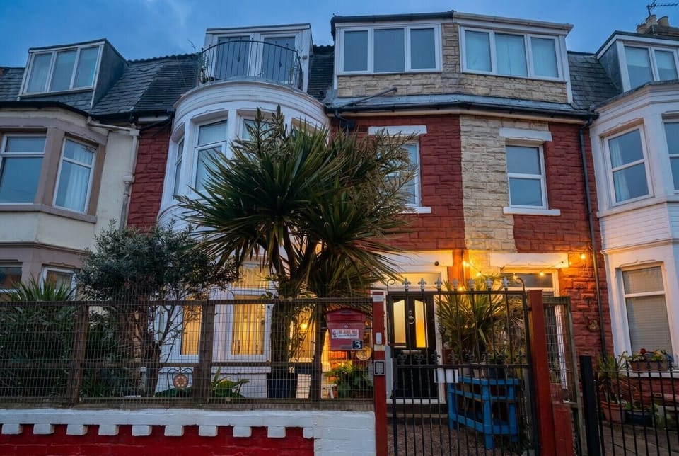 Warm welcome home with glowing lights and palm-framed entry at dusk.