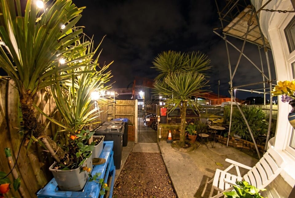 Fairy-lit courtyard garden with palm trees and a seating area for evening fresh air.